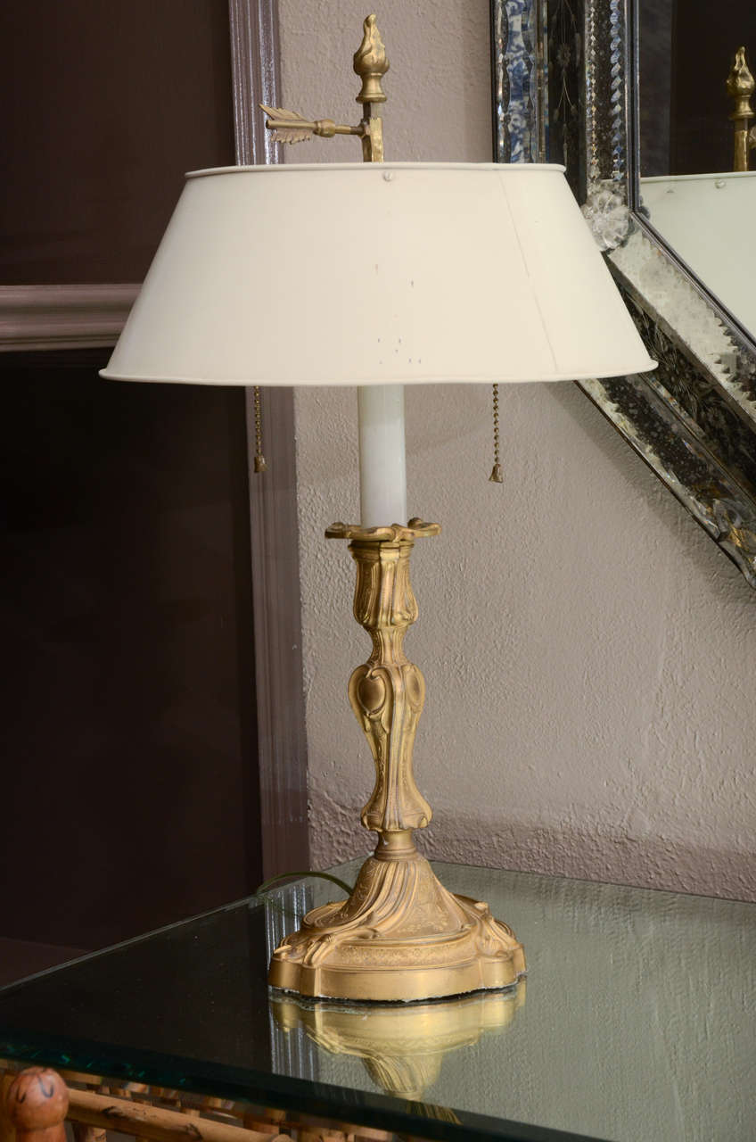 Gilt metal candlestick lamp with white tole shade. The height to the top of the finial is 22.5 in