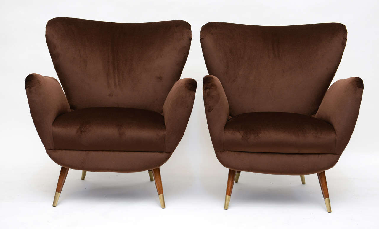 Exquisite brown velvet on this highly sculptured pair of Italian armchairs with details aplenty.  Brass tip legs, soft curve to wing top and detached arms.

Upholstered to perfection, back to its glorious perfection.

This item is now located in