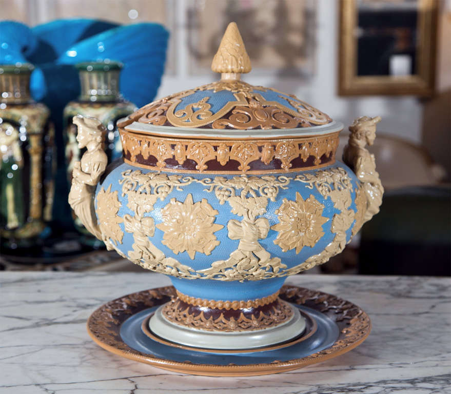 Offered here is a rare 1894 monumental stoneware Villeroy & Boch Mettlach punch bowl tureen with figural handles, cover and underplate.  Ivory and sky blue coloring and stamped with the Villeroy & Boch Mettlach mark, this excellent piece is in the