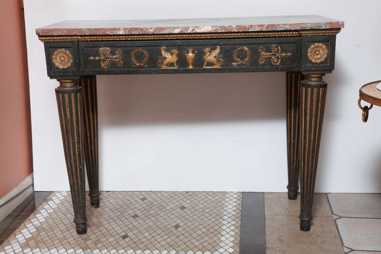 A Baltic green painted and gilt decorated rectangular center or hall table with a marble top and neo-classical ornamentation to the frieze, on bold reeded tapering legs.