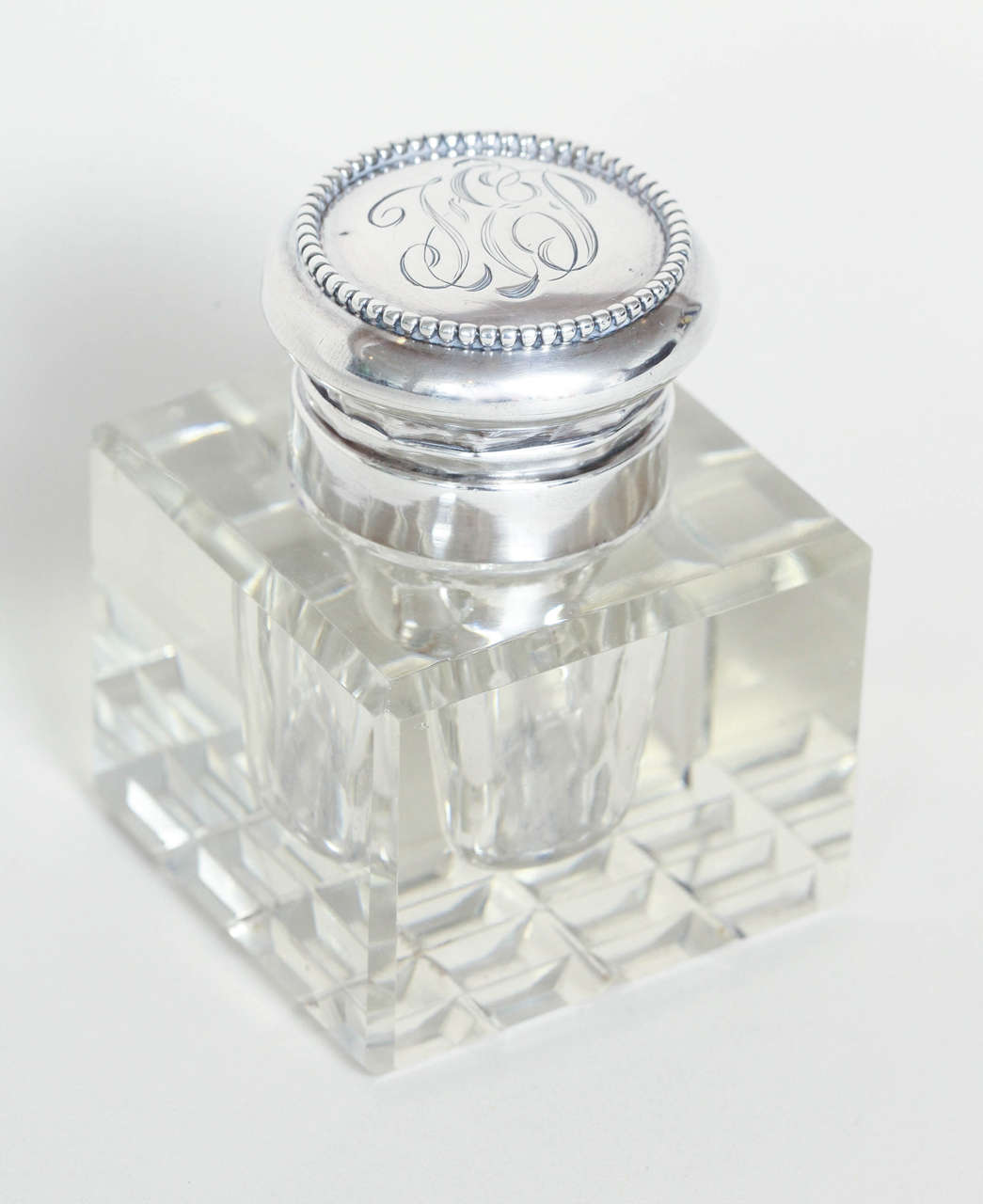 Cubic crystal inkwell/paperweight with base of 16 beveled squares.
Monogrammed TEP on top.

Hallmarked STERLING/1928.
