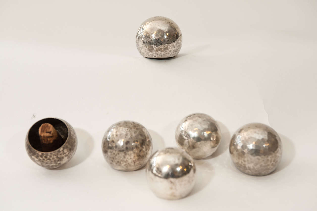 A group of  six hammered metal silver platted bottle stoppers which includes one stopper designed by Josef Hoffman for the Wiener Werkstatte, signed WW and HJ.