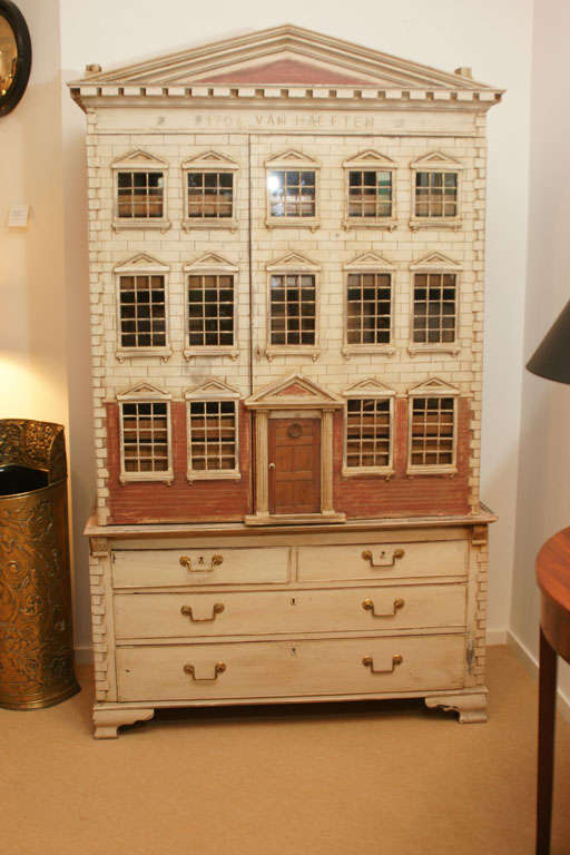 A wonderfully imaginative piece taking a 19th century linen press faux painting and reconstructing the top half into a fantasy doll house on the outside, but inside a Classic linen press with pull-out shelves and one long drawer. The bottom section