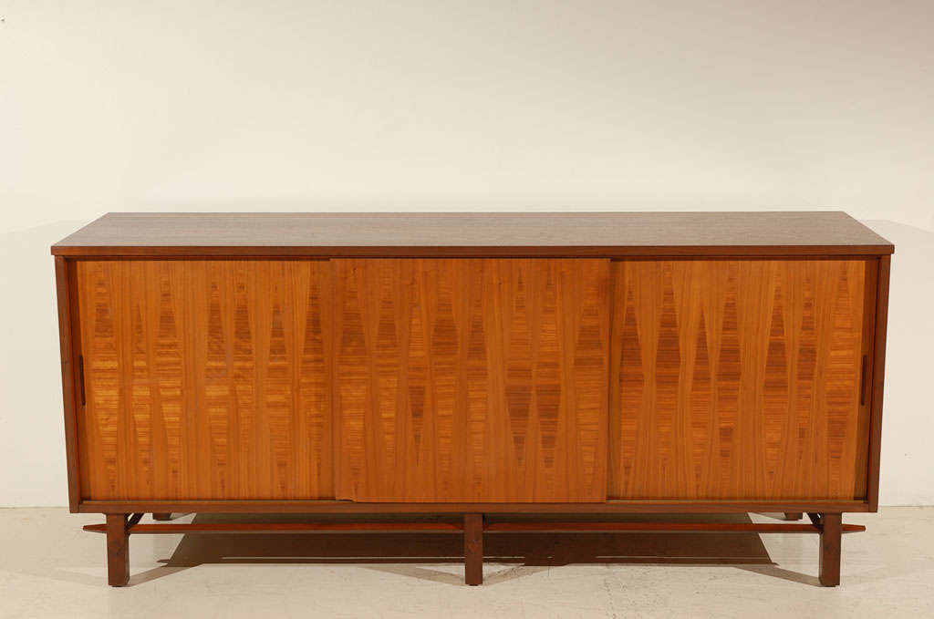 Walnut credenza with inlaid diamond veneer details.  Made by Heritage.  Interior has one set of 4 doors and two spaces with adjustable shelves.