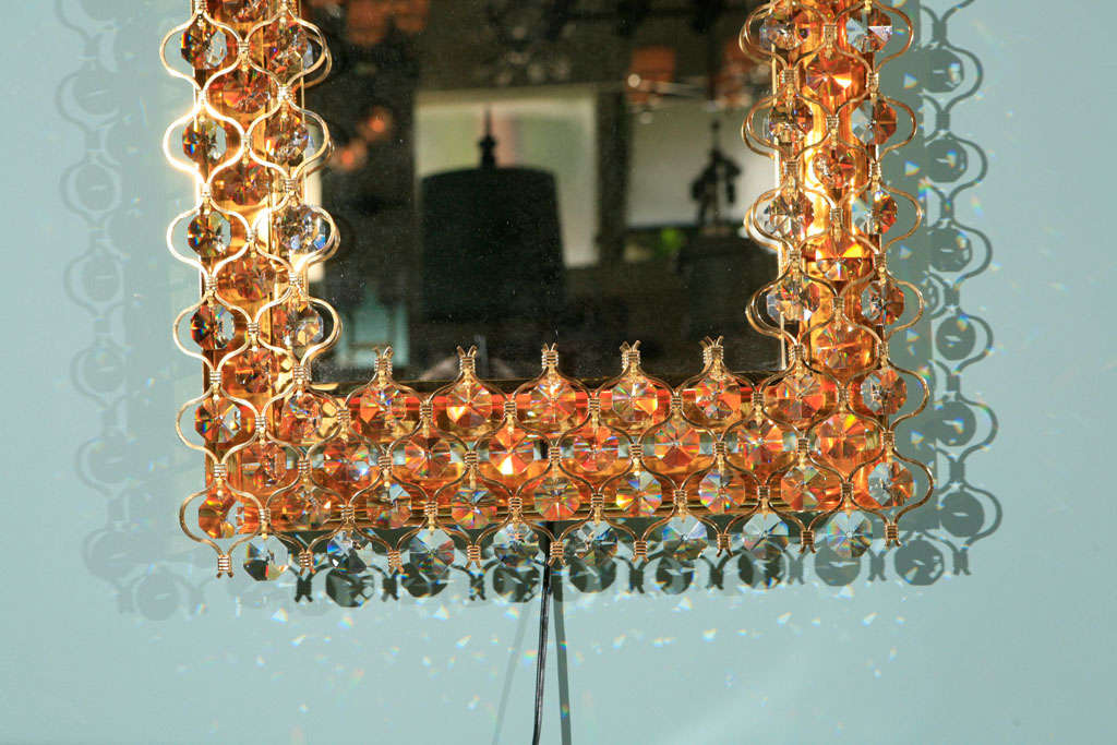 Rectangular Lobmeyr backlit mirror surrounded in crystals and gold.