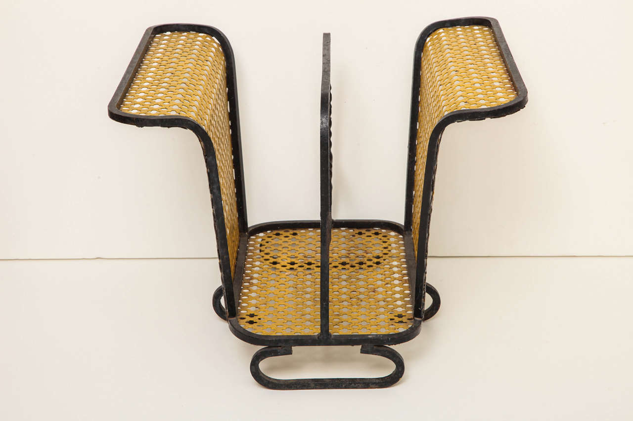 A mid-20th century wrought iron, painted and perforated metal magazine stand in the manner of Mathieu Mategot, circa 1950