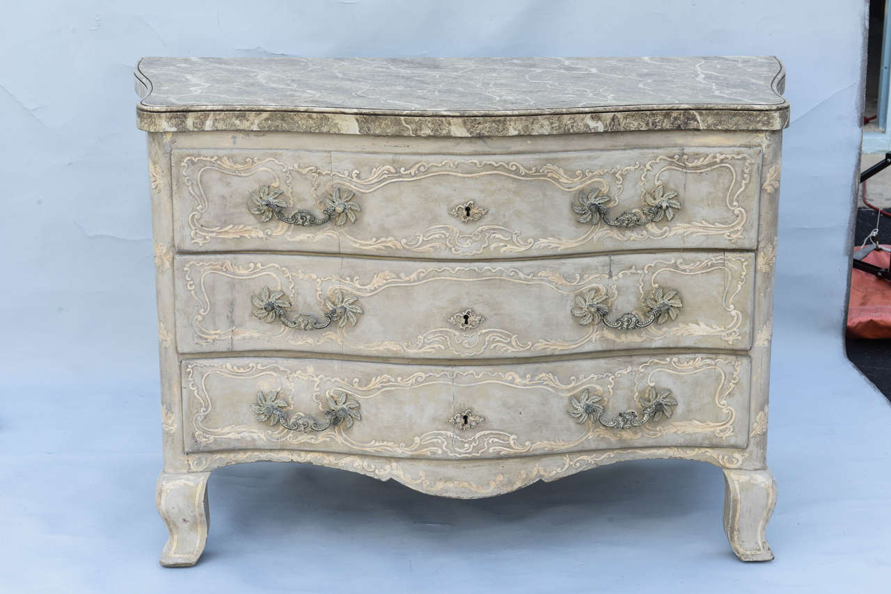 Commode, having a faux mabre molded top, on conforming case, its three stacked drawers flanked by stiles, all decorated with pastiglia scrollwork and foliate, similarly embellished serpentine apron, raised on squared cabriole feet.

Stock ID: D1297