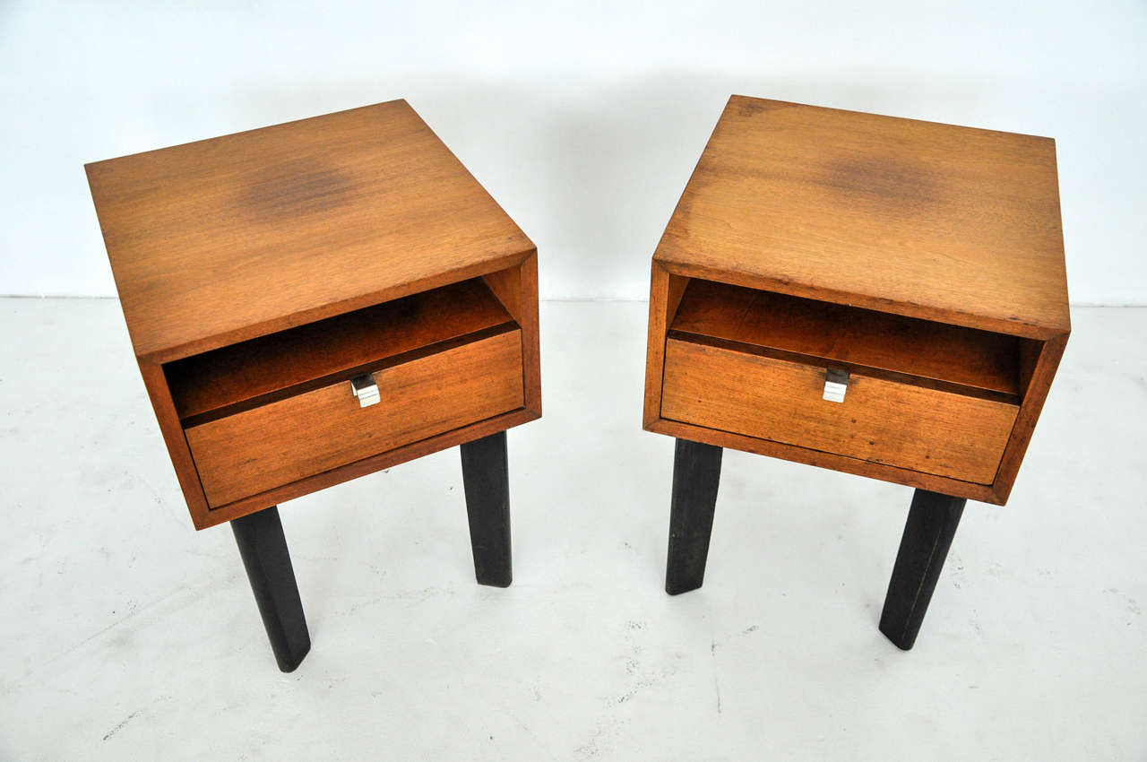 Pair of nightstands or end tables designed by George Nelson for Herman Miller. All original walnut finish with ebonized legs. Original finish shows vintage wear.