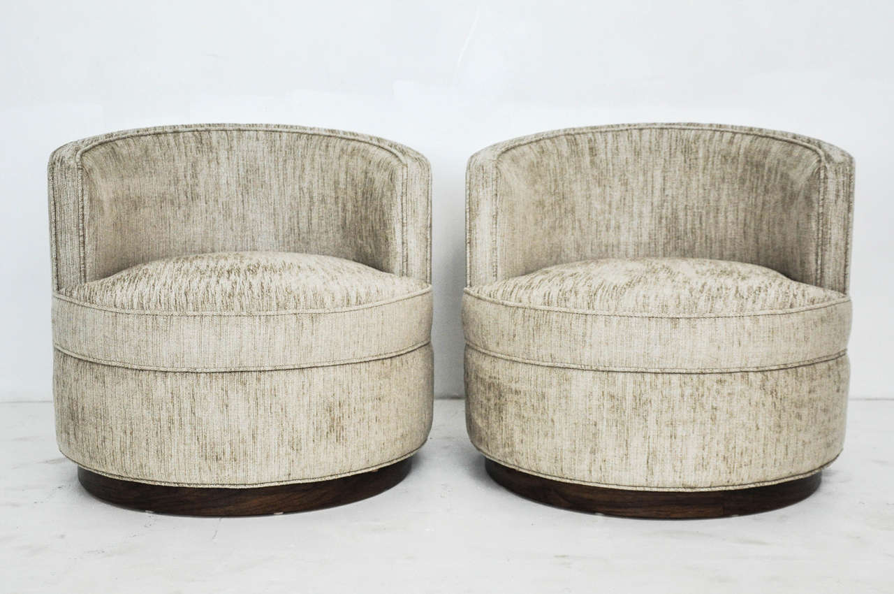 Pair of early Dunbar swivel chairs with dark finish mahogany bases designed by Edward Wormley. Newly upholstered.