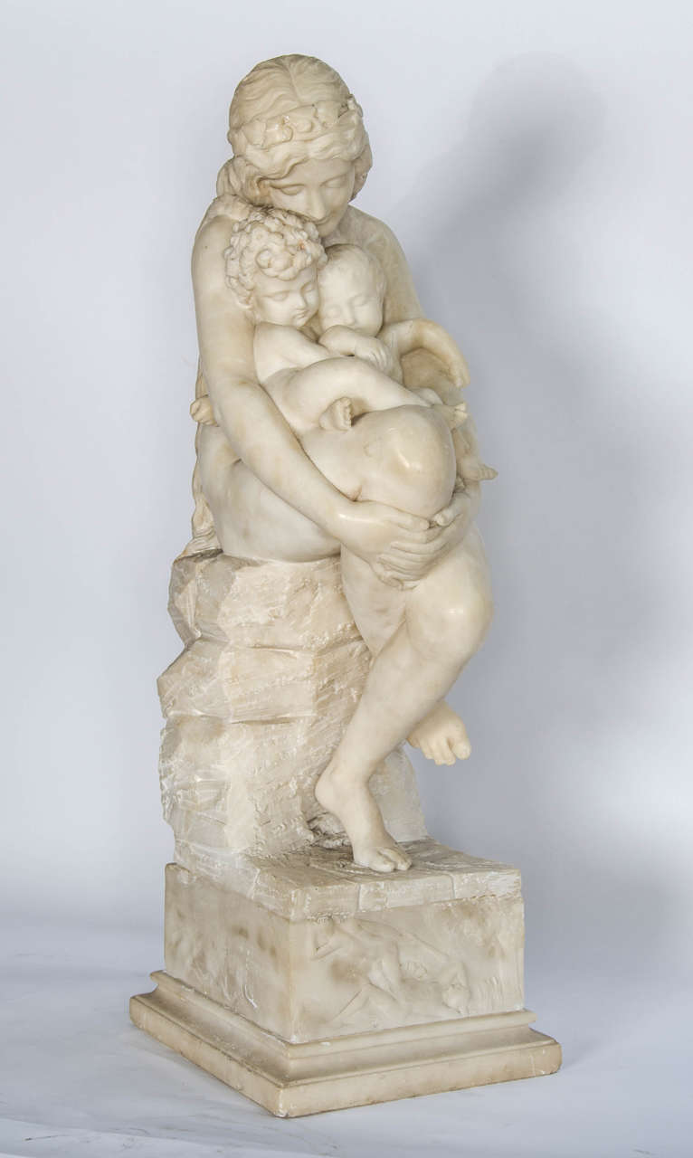 An enchanting Italian, 19th century Alabaster study of a mother and her two children, seated on a rock.