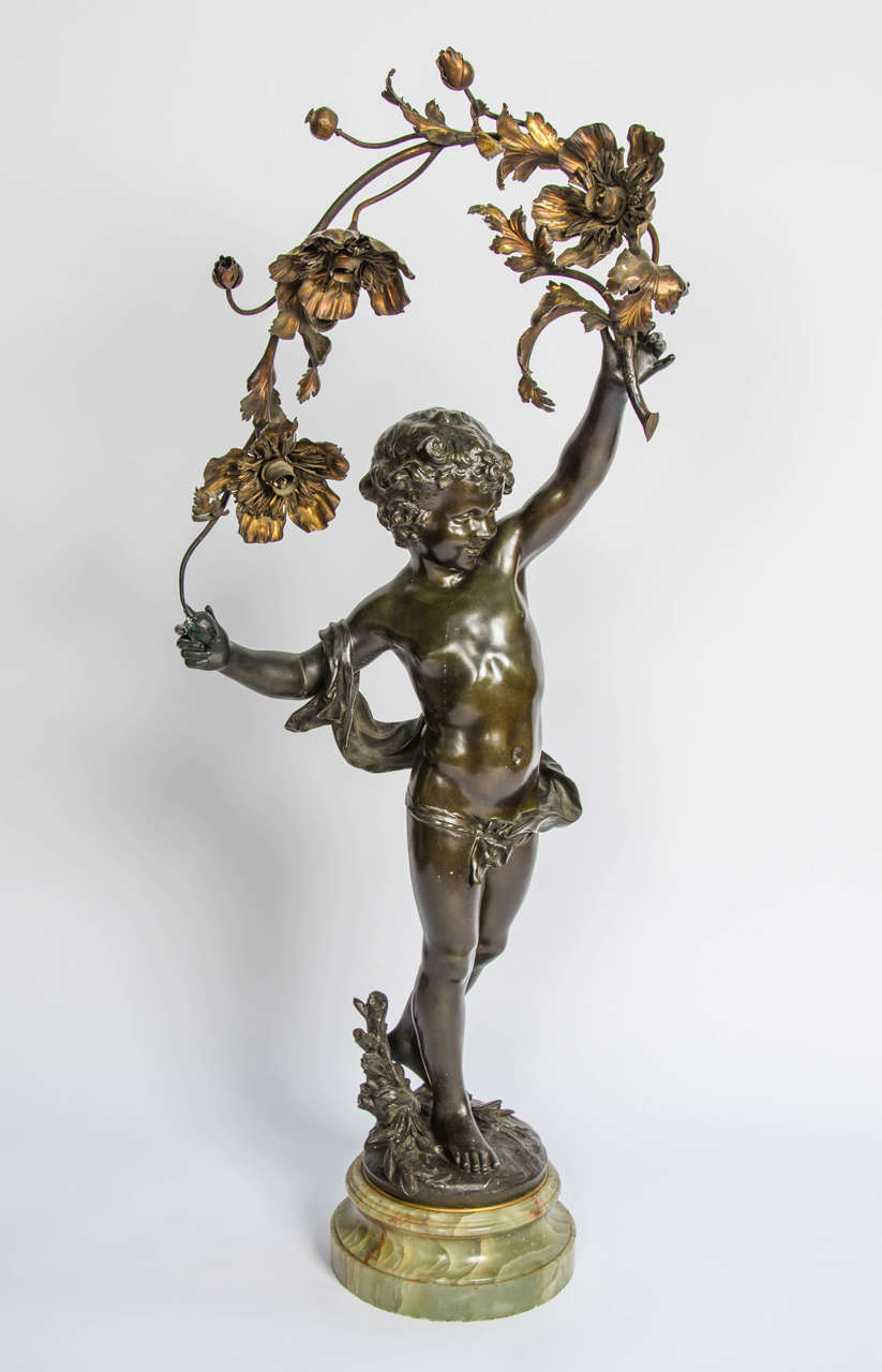 A very good quality French bronzed statue of a child holding a branch of flowers, mounted on an onyx base, circa 1890. 
Electrified.