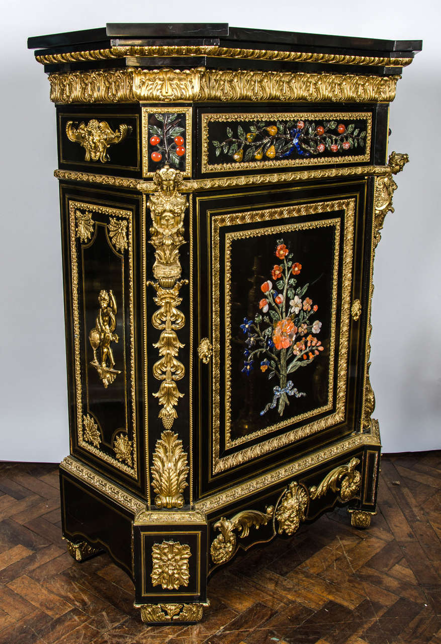 A monumental pair antique Pietra Dura inlaid ebony veneered pier cabinets. Have the original black marble tops, wonderful gilded ormolu mounts and inlaid foliate decoration to the doors.