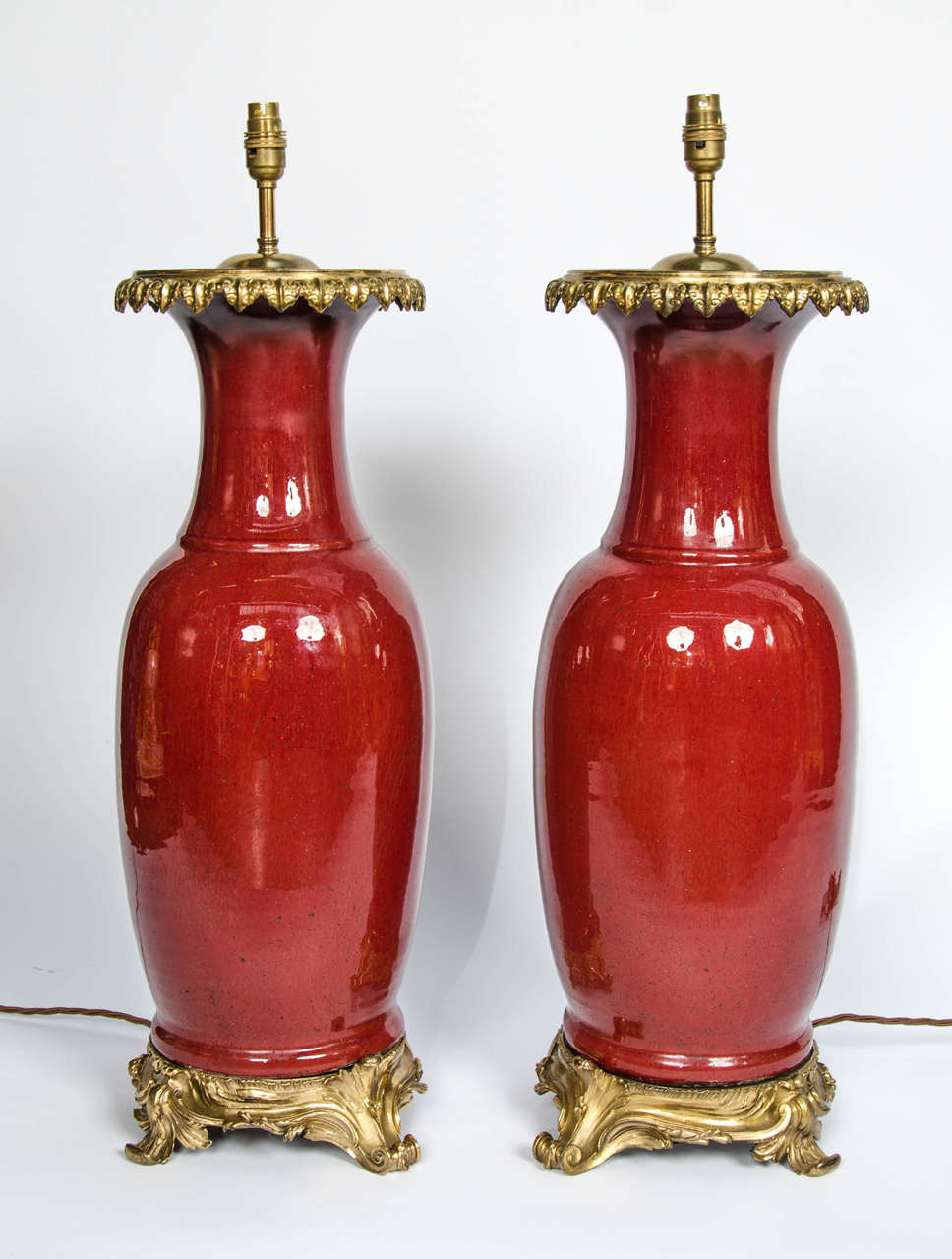 An impressive pair of 19th Century Chinese Sang De Boeuf vases with French Rococo style ormolu mounts, converted to lamps.