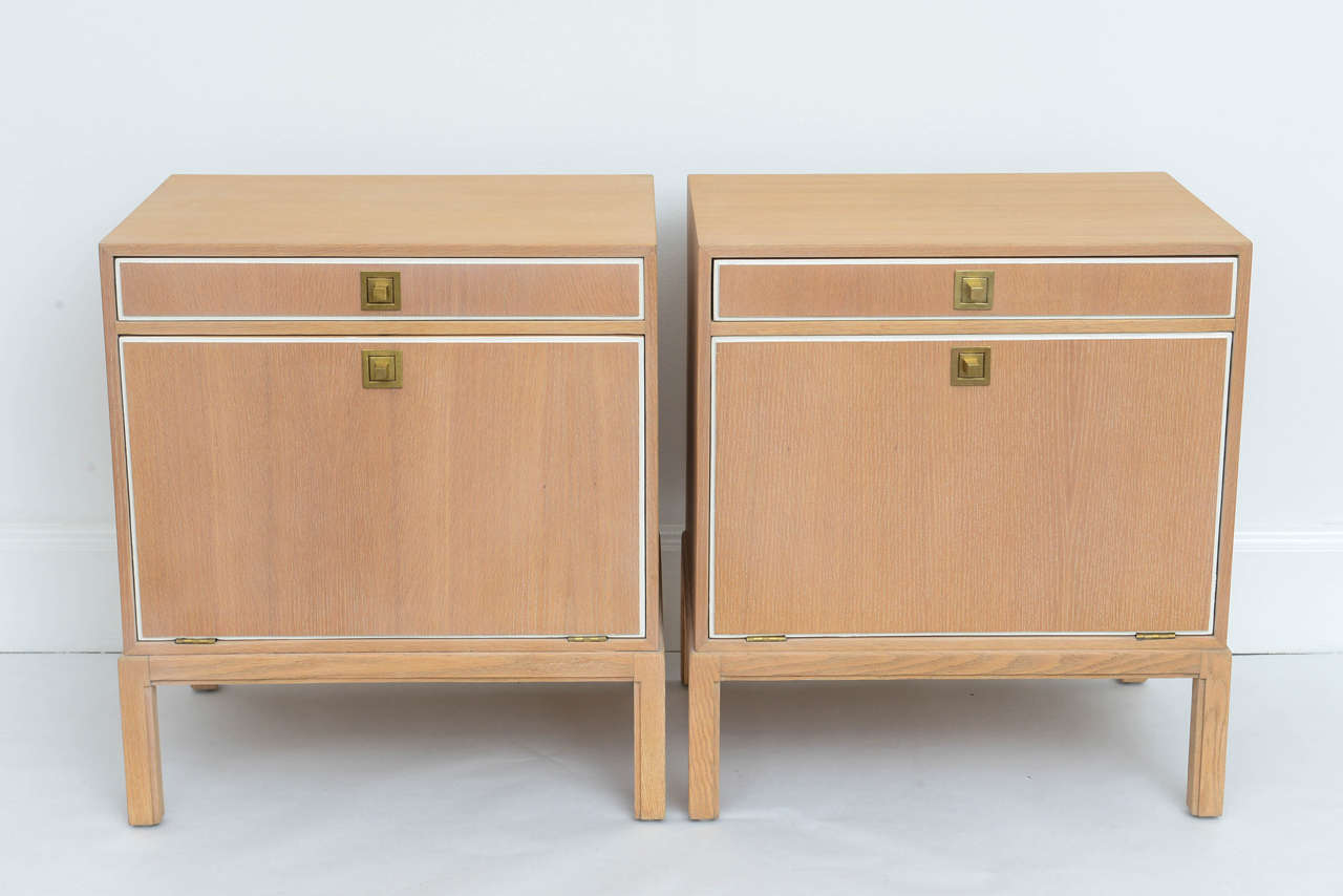 Beautiful example of classic Parzinger re-envisioned in an elegant weathered-oak finish. The softness of the wood is only further accentuated by inlaid off-white lacquer detailing and brushed brass hardware. 

Pair of side tables featuring slim