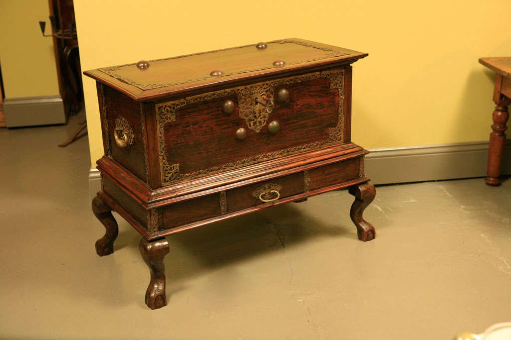 A two-piece Dutch Colonial chest and stand with beautiful brass filigree detail and stylized cabriole leg and ball and claw foot. Suitable as chest or small console table.