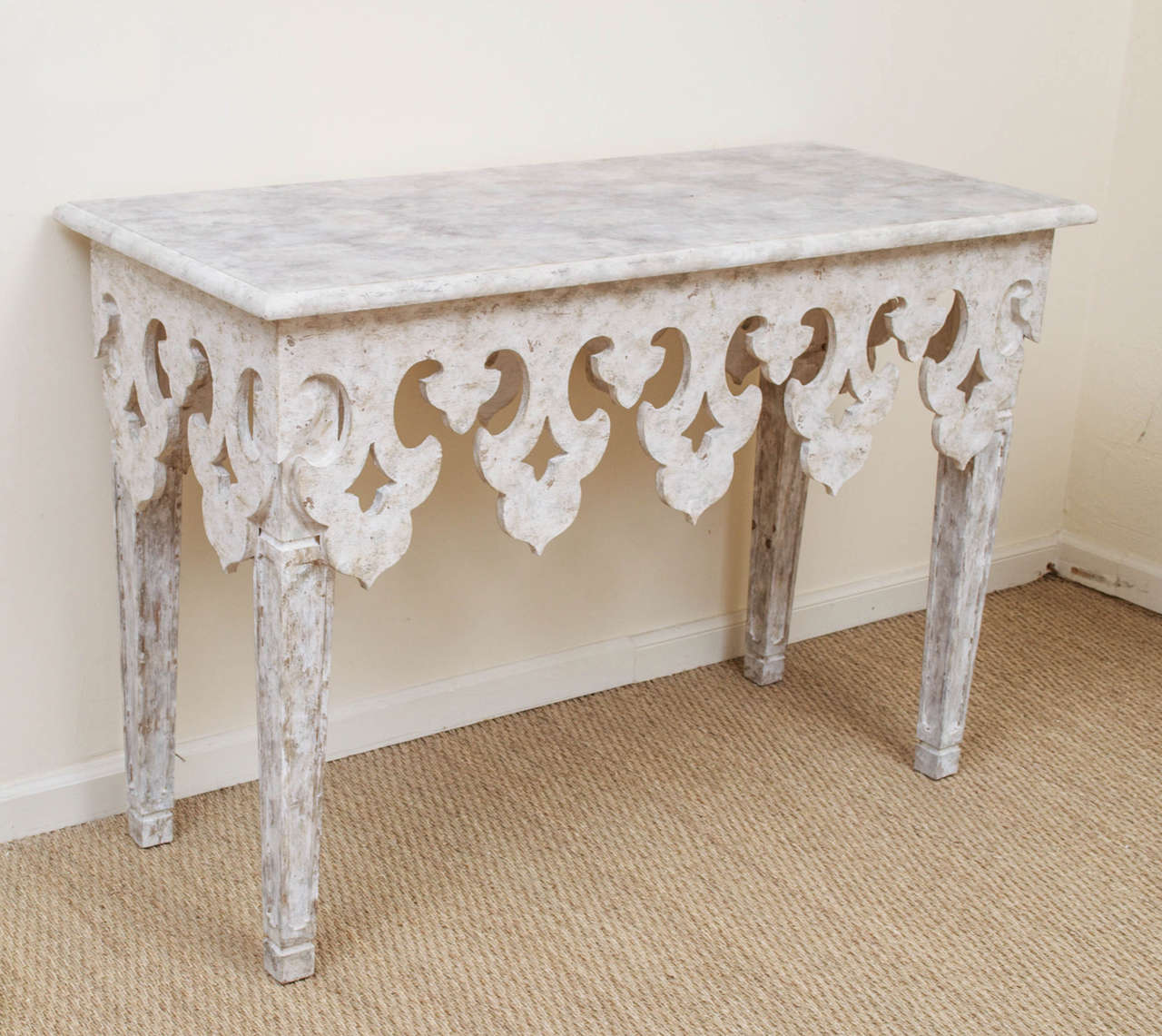 A painted and decorated console table with a carved 