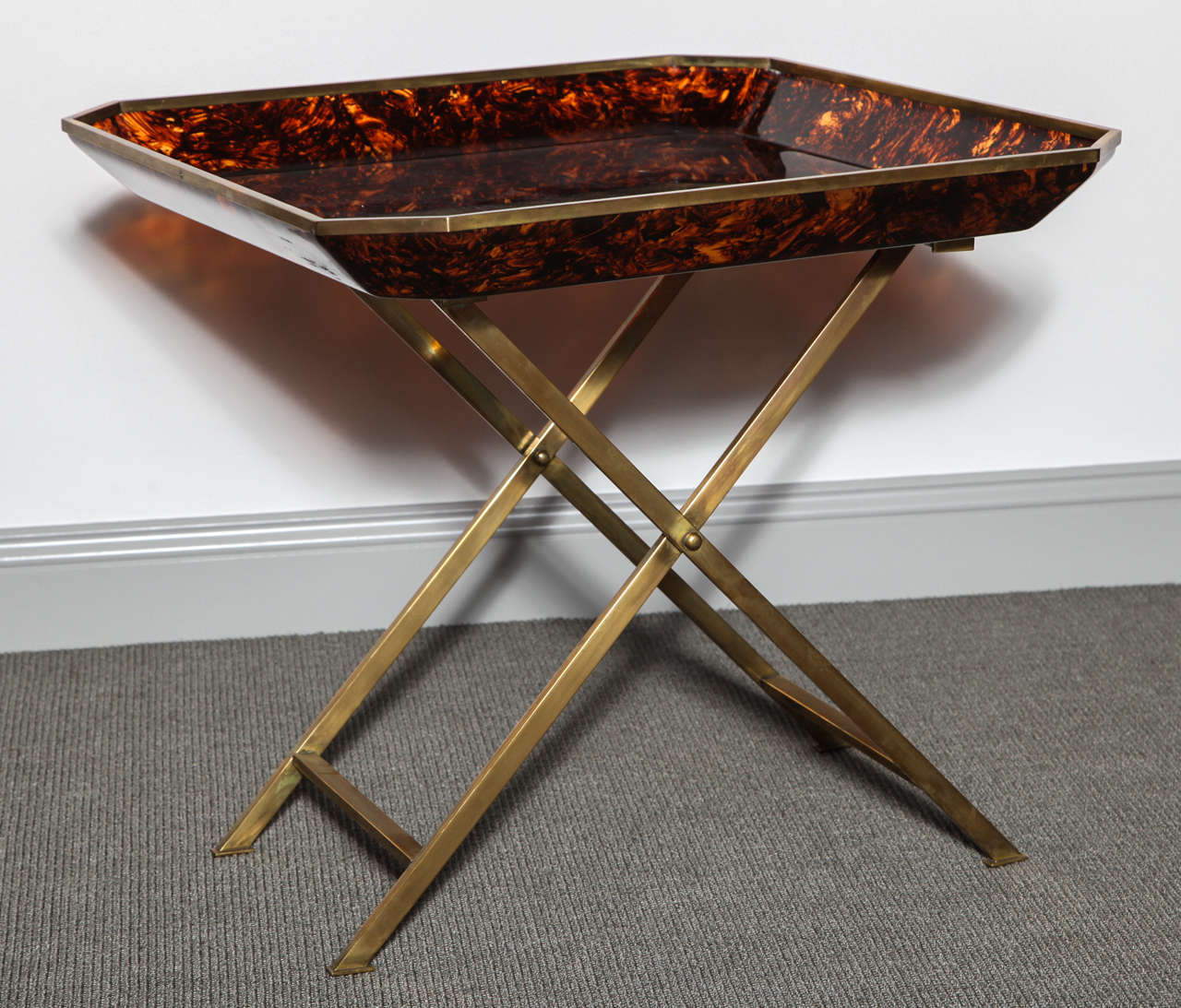 This chic Butler's tray table consists of an octagonal faux tortoiseshell acrylic tray with a brass edge and a delicate X-brass base.