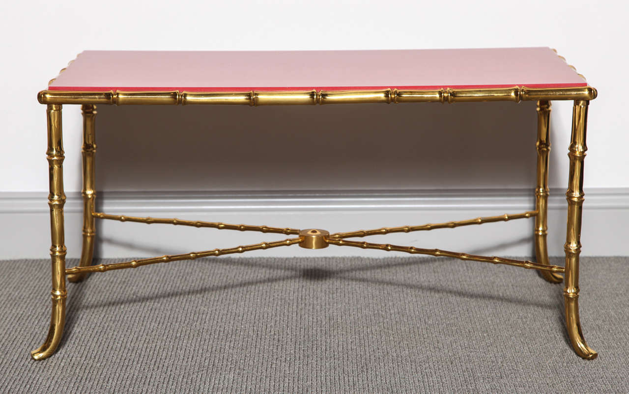 A Maison Baguès bronze faux bamboo coffee table, with an X-stretcher base with a red stone inset top.