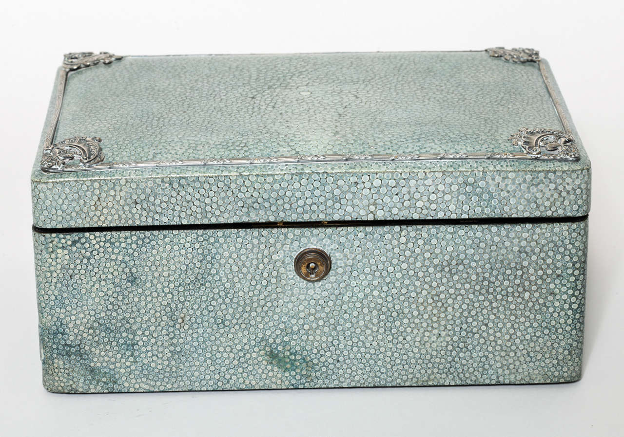 Polished green shagreen jewelry box with silver mounts on the top and lined in silk and velvet. Has lock stamped BRAMAH LONDON, but no key.
Hallmarks: 925 silver/ London/ 1910/ S J
Stamped: 
