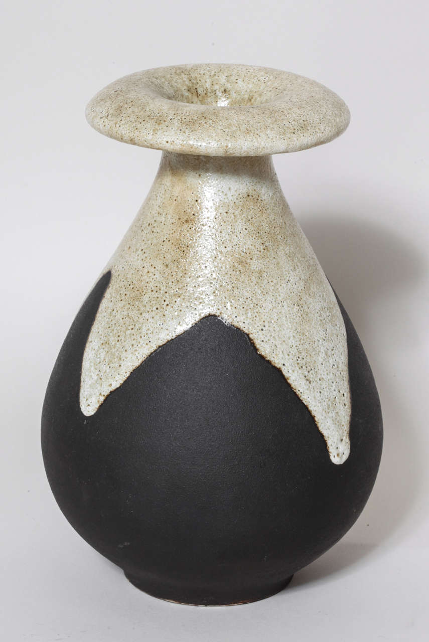 Tall pear-shaped vase with an everted circular crown superiorly and white and beige enamel on a brown ground.
Signed: ''R. Rumebe'' in enamel

Provenance:
Collection of Patricia Monjaret & Marc Ducret.
