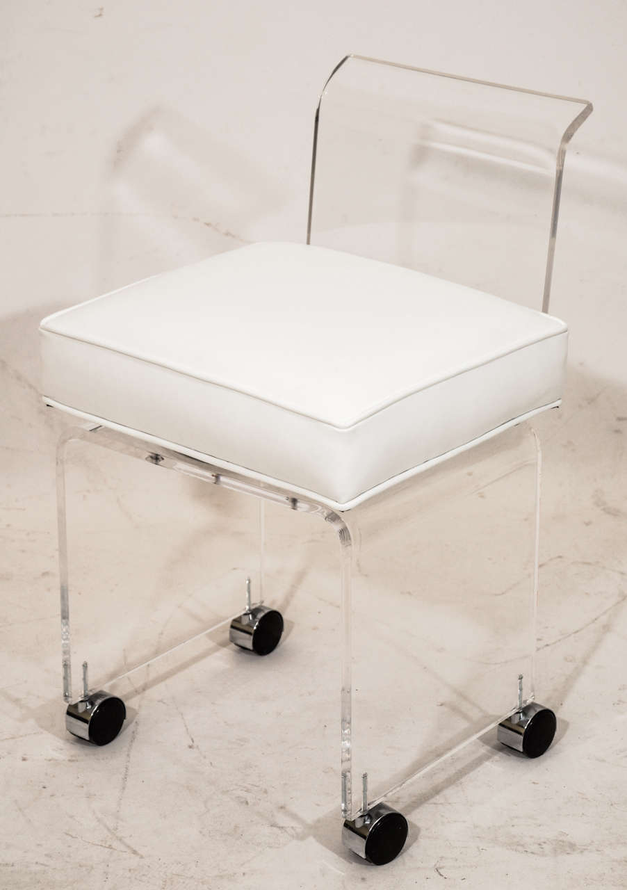 Very pretty and petite  lucite vanity swivel chair upholstered in white leather.