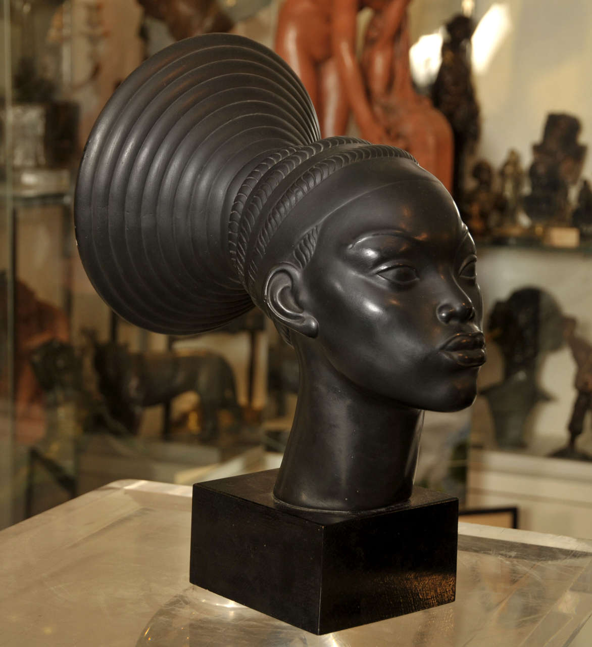 1930s patinated plaster bust of an African woman from the Mangbetu tribe, signed by  C. Andrea; set on a wooden base.