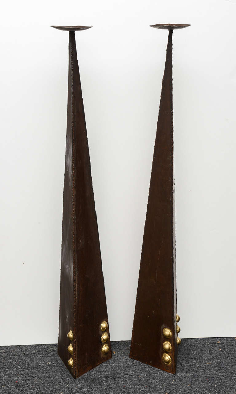 A pair of unusual sculptural candlesticks made of iron. 46 inches high, can certainly be used in many spaces for different effects.