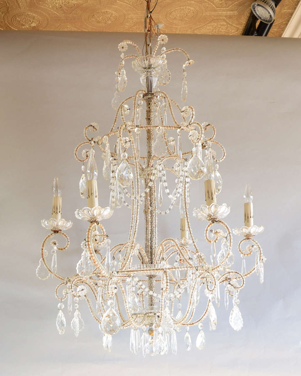 Crystal chandelier, having two tiered, cage-form frame of gilded iron, entirely encased in crystal beads, six scrolling candlearms with scalloped glass bobeches; draped in crystals and prisms.

Stock ID: D6787