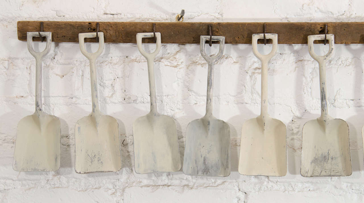 American White Sandshovels Suspended from Wooden Rack with Iron Hasps