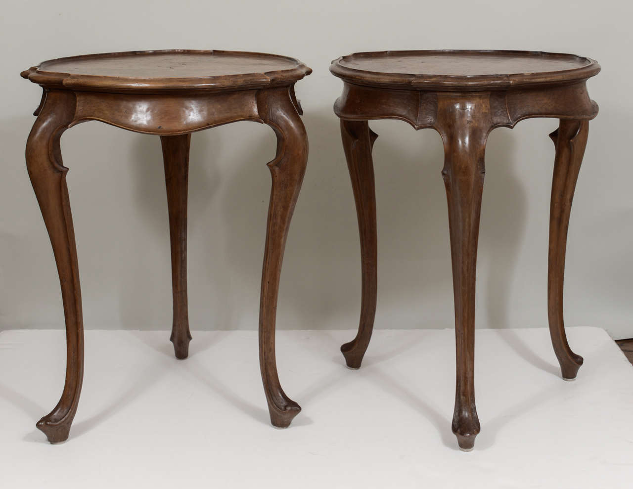 A pair of 19th century Spanish carved walnut tables with cabriole legs and curved, flared skirts. In wonderful condition.