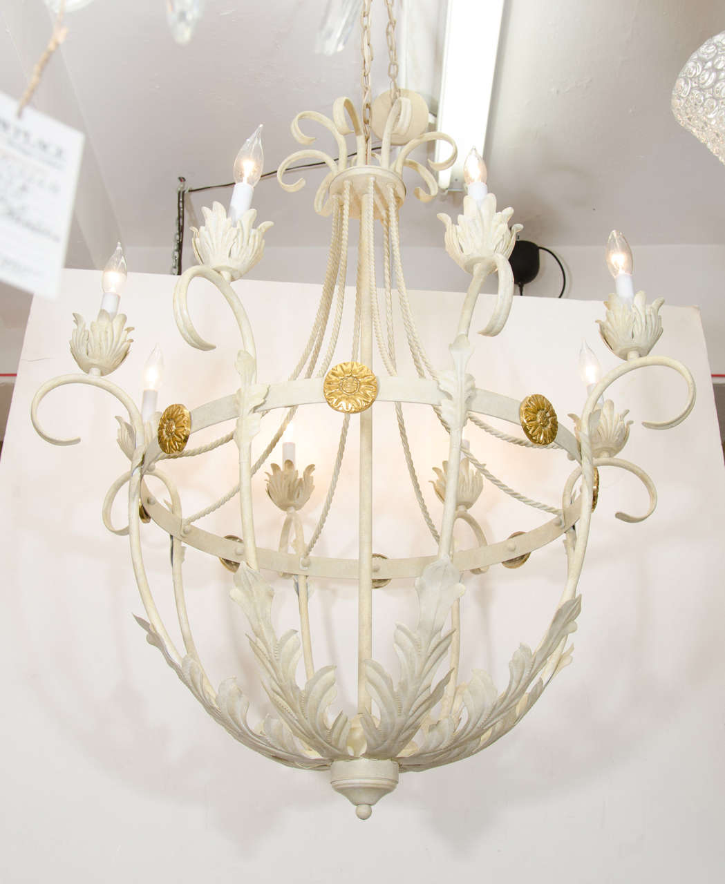 A vintage iron basket form chandelier painted white with leaf detail and brass florettes. Newly rewired. Good vintage condition with age appropriate wear.