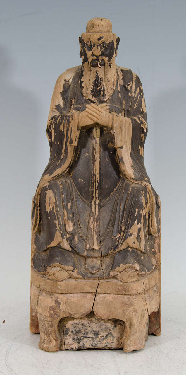 A large carved wood sculpture of a Taoist guardian figure with inset eyes from the Ming Dynasty.  The body has traces of gilt lacquer.  The reverse has a space to enclose magic relics.  At the bottom there is a hand grip to hold up the figure during