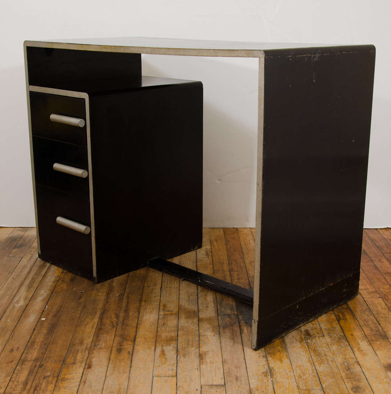 An Art Deco black and silver enamel desk attributed to Paul Frankl.

Good vintage condition with some scratches and wear.