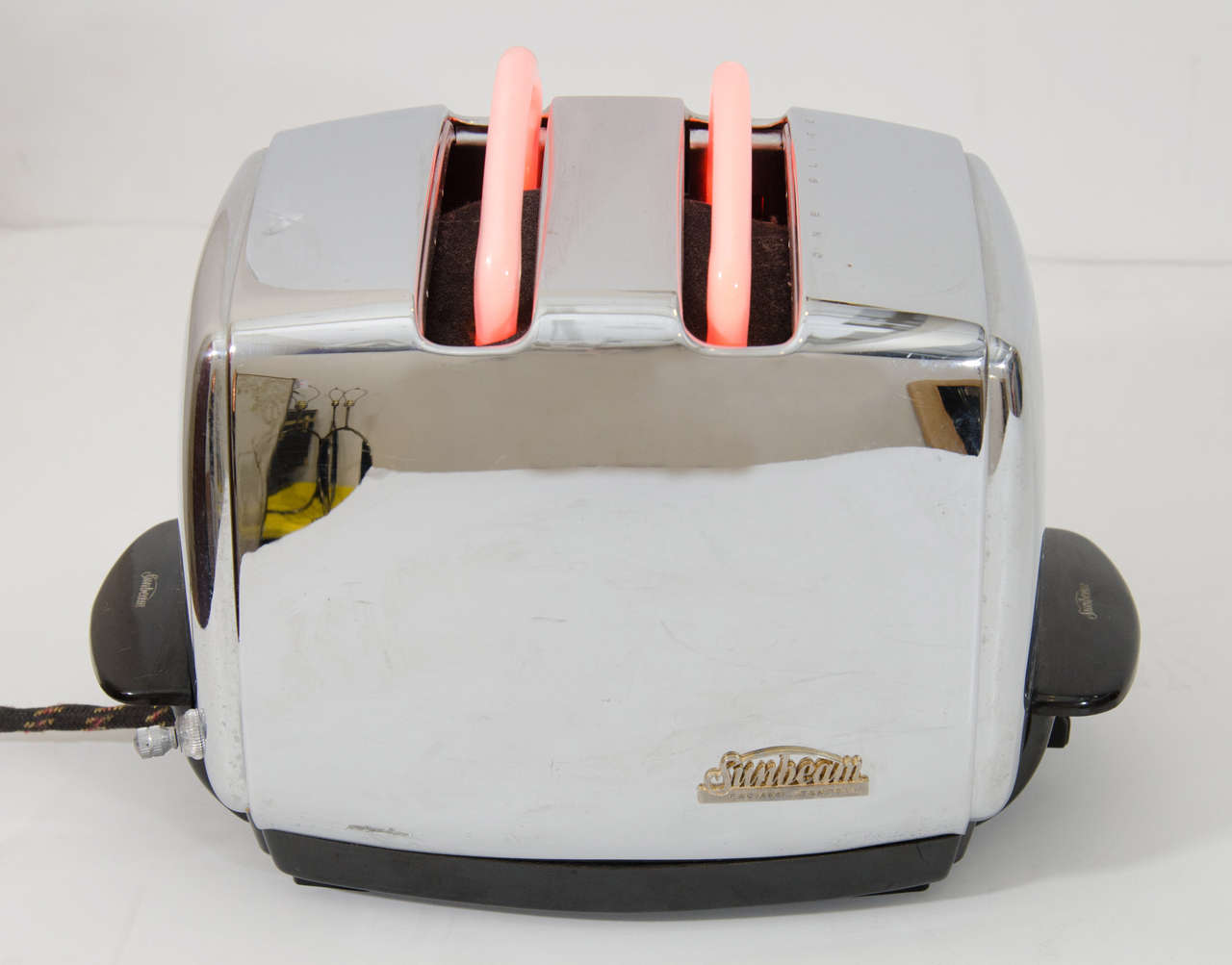 A vintage toaster by Sunbeam circa 1940s adapted into a neon light sculpture in the 1980s. The neon light forms toast. Original cloth wrapped cord. 

Good vintage condition with age appropriate wear.