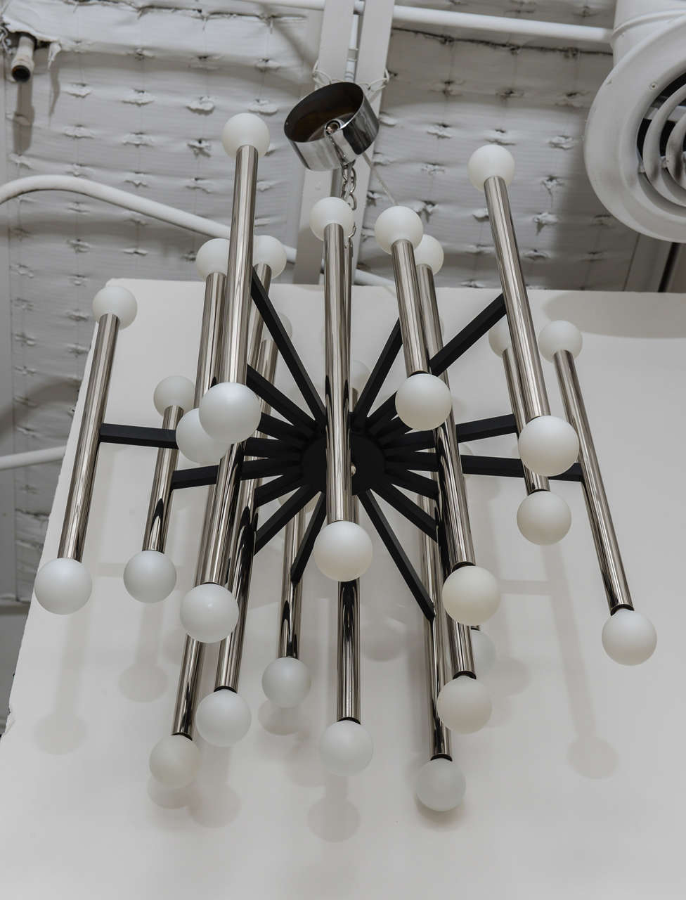 Sublimely simple and modern 36-light chandelier by Gaetano Sciolari, circa 1968. Black spokes radiating from the center support 18 polished aluminum vertical rods with sockets at both ends. Canopy retains original Sciolari label.