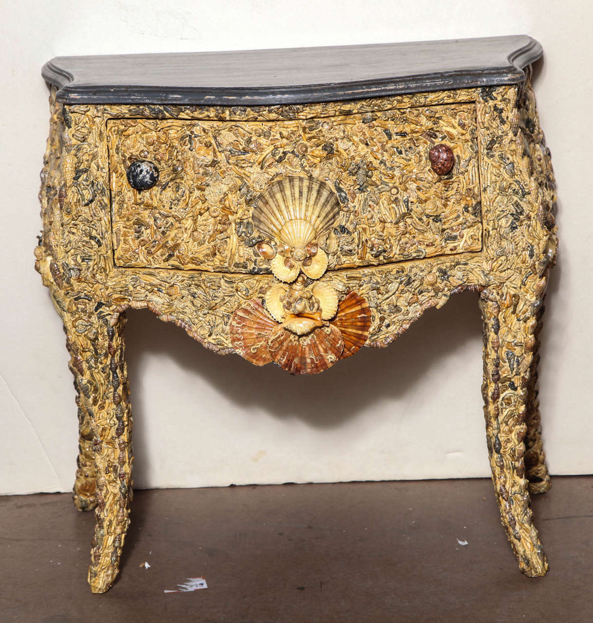 19th century Italian grotto shell commode with faux grey marble painted serpentine top over a drawer with shell pulls; on inward curving legs. Signed 