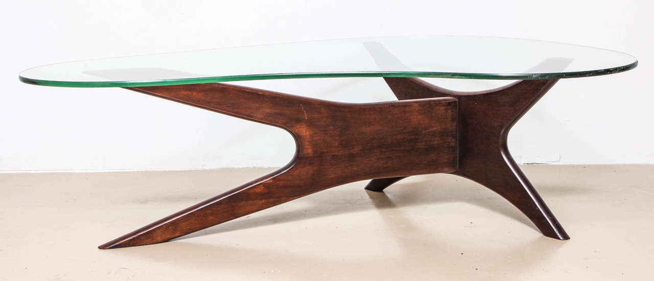 The free form glass top resting on the walnut base.