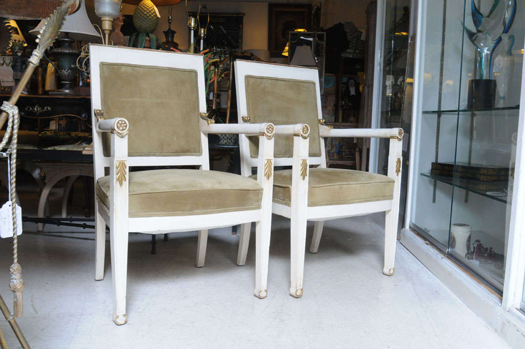 Elegant pair of Directoire armchairs with original paint and gilt finish. New suede and silk upholstery.