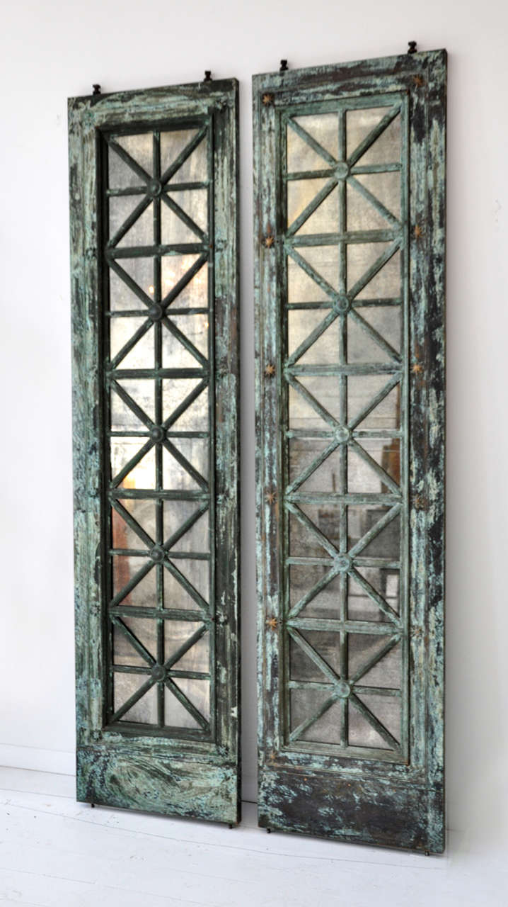 Salvaged vintage elevator doors from an apartment building in New York City. Originally there were three sets, but this is the only one remaining. Antiqued Copper with vintage mirror.