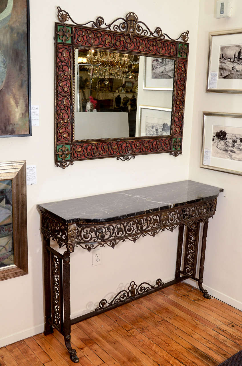 A bronze and iron Oscar Bach console table with a marble top. The bronze is adorned with comedy masks and fruit motif. The bronze mirror is decorated with a tragedy mask and fruit motif with dragon and bird accents.

Mirror is 36" x