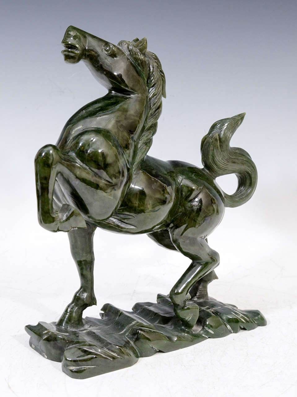 A circa 1920s jade sculpture from China, depicting a horse in mid-stride.
