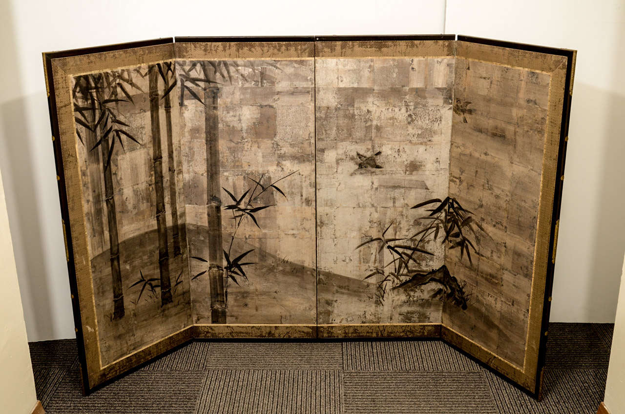 An antique Japanese Momoyama period screen with four folding panels decorated with a bird and bamboo motif. The piece is done in sumie with a varnished oxide patina. The piece is in good antique condition with age appropriate wear.