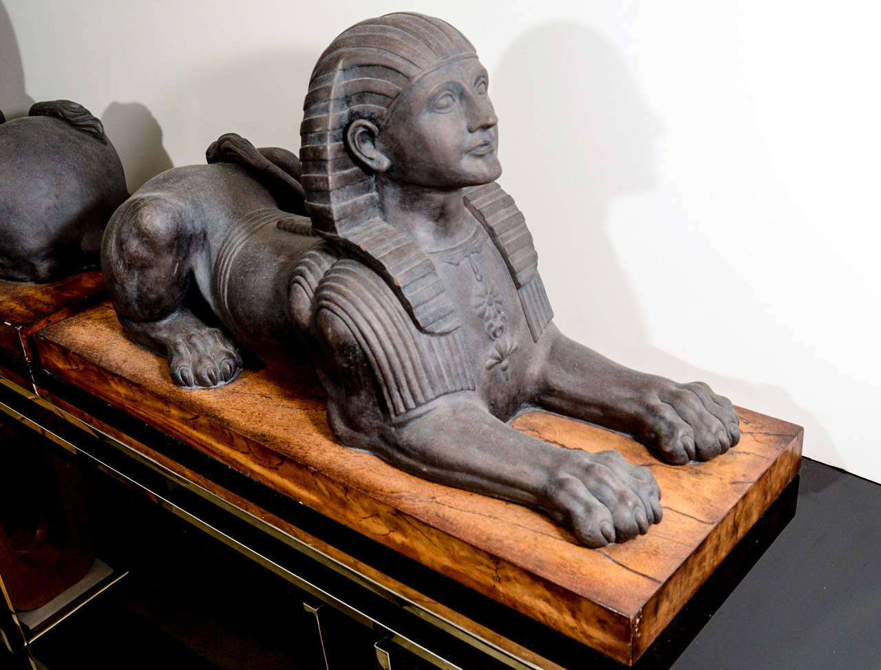 A pair of vintage matte glaze ceramic Sphinx on wooden bases.