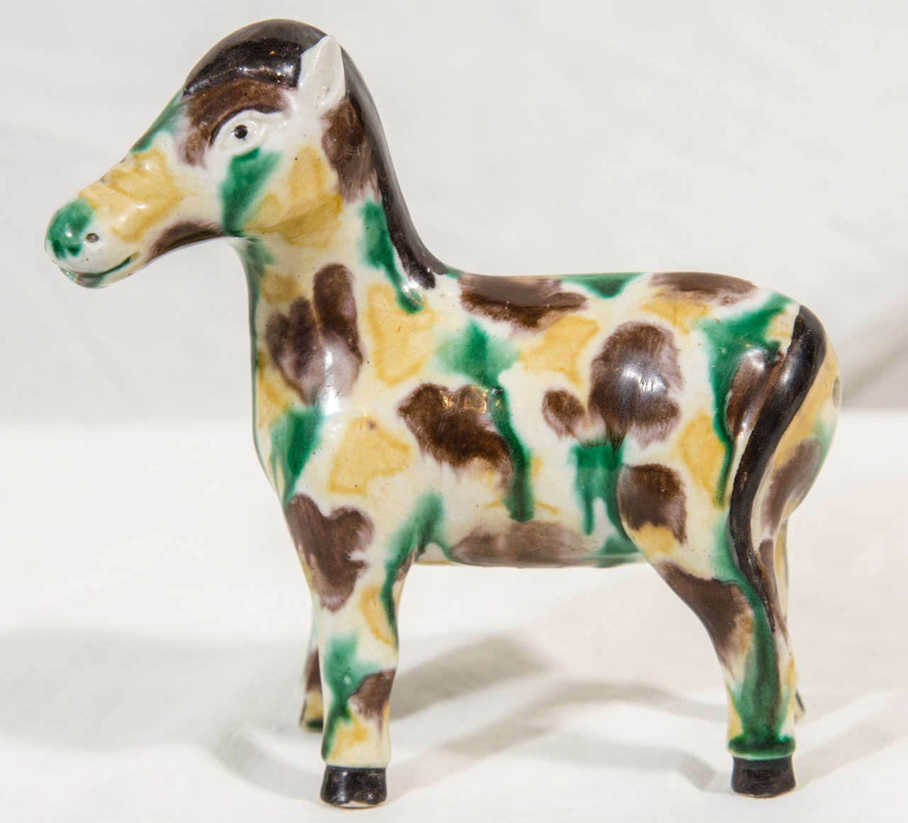 A Chinese export water dropper in the figure of a horse. The figure is decorated with an egg and spinach, three color,Sancai glazed design.