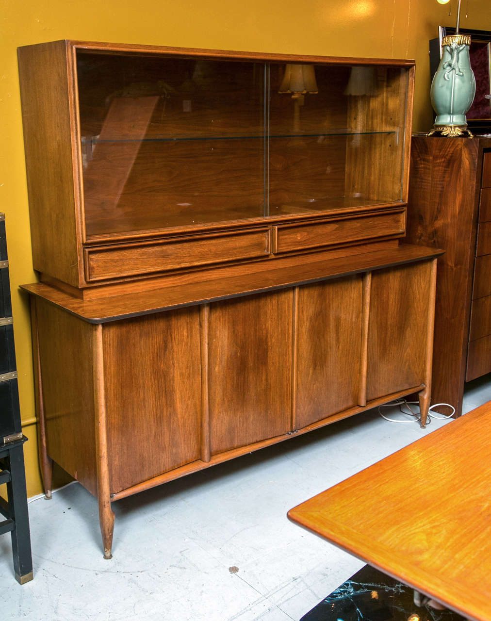 Mid 20th Century Modern Van Leigh New York - Montreal Walnut Breakfront. The sideboard four drawer case supporting an upper showcase / bookcase top over two drawers. Sleek modern line and class sliding doors. 

Top Measures: 29 Height  57 3/4