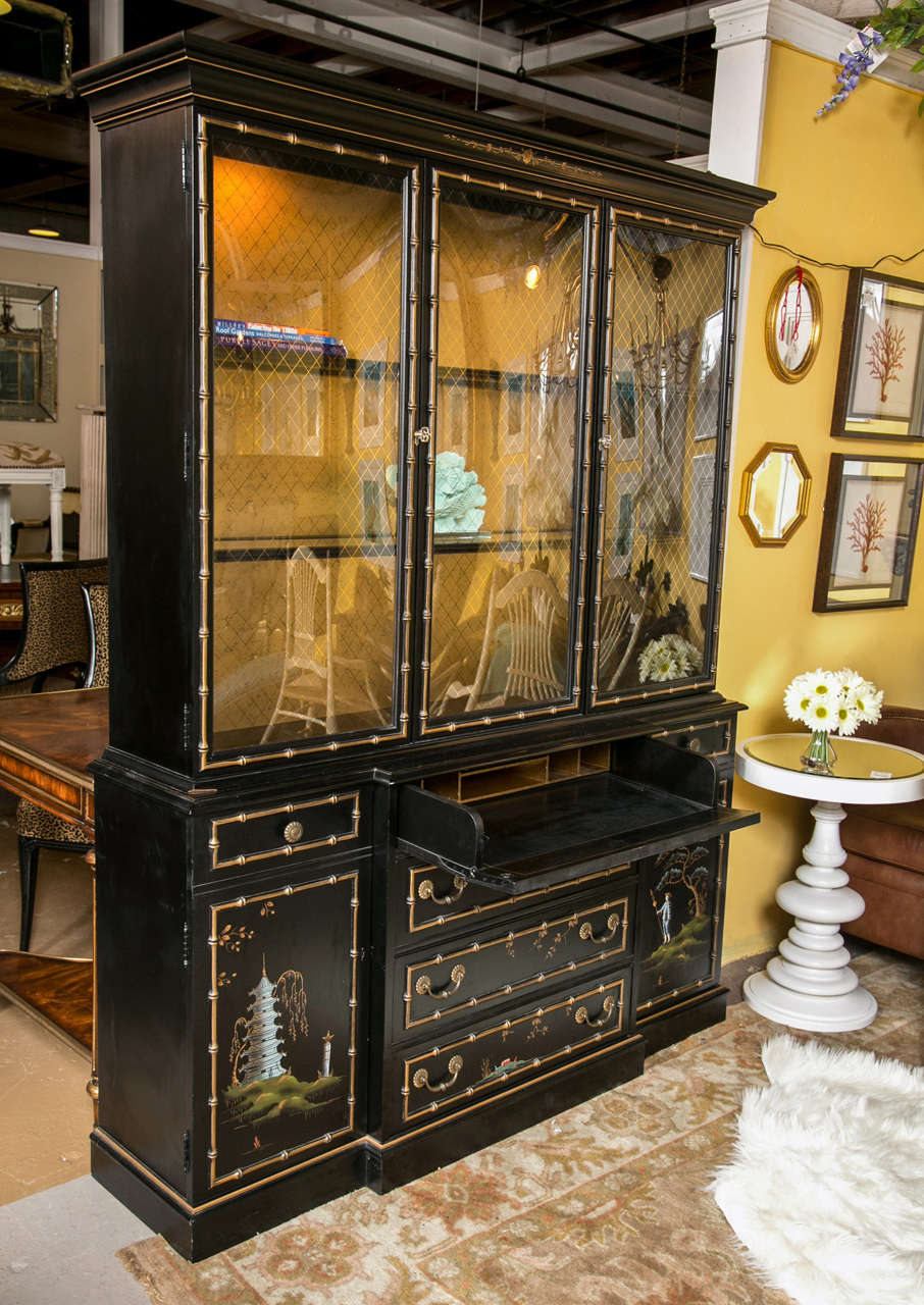 A Chinoiserie China Cabinet / Breakfront of custom quality, possibly John Stuart or John Widdercomb. The cabinet with all over Chinoiserie Paint Decoration. The center lower casing conforming of four drawers, all faux bamboo framed, the top one