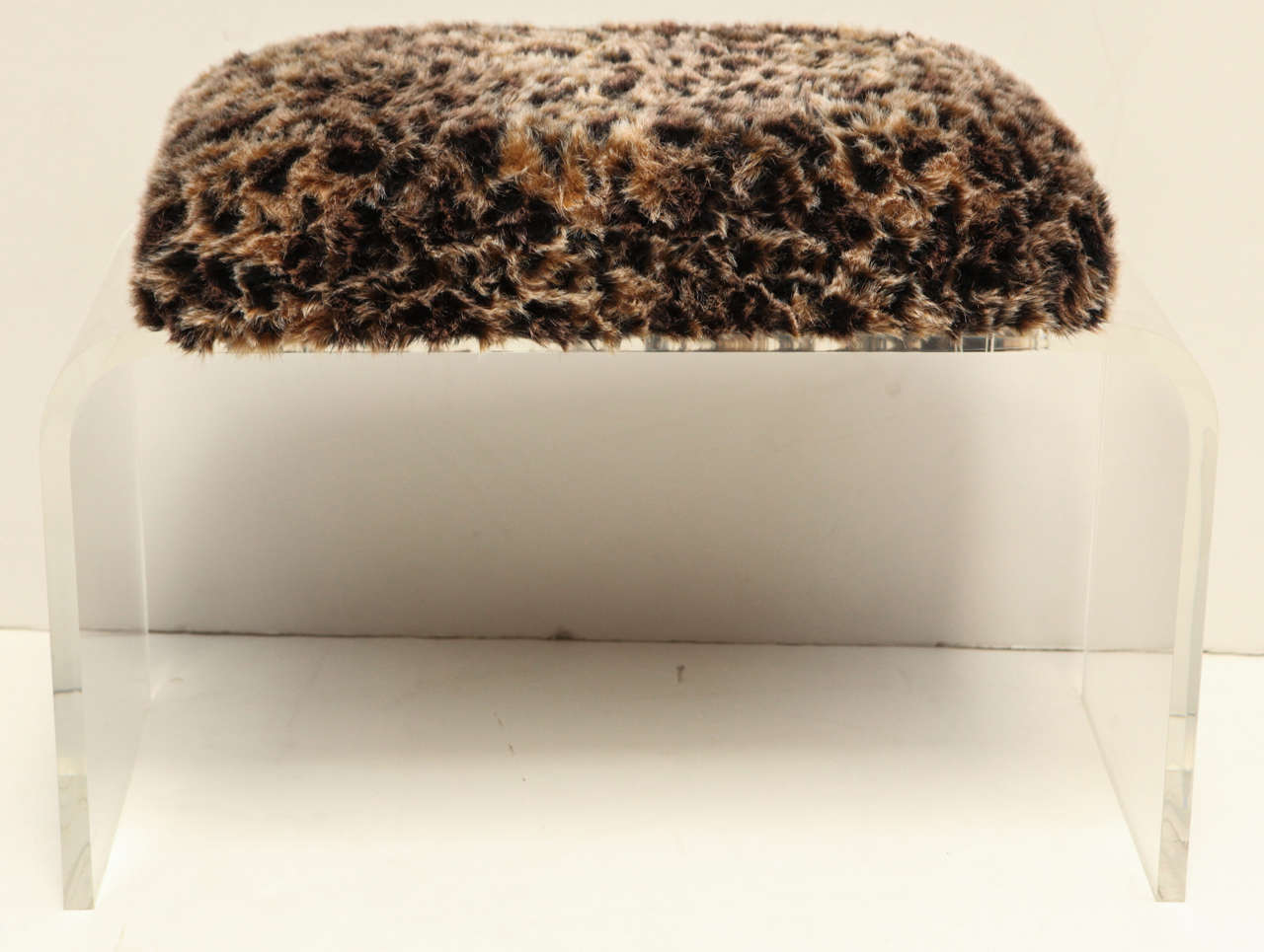 Faux cheetah fur and lucite base ottomans.