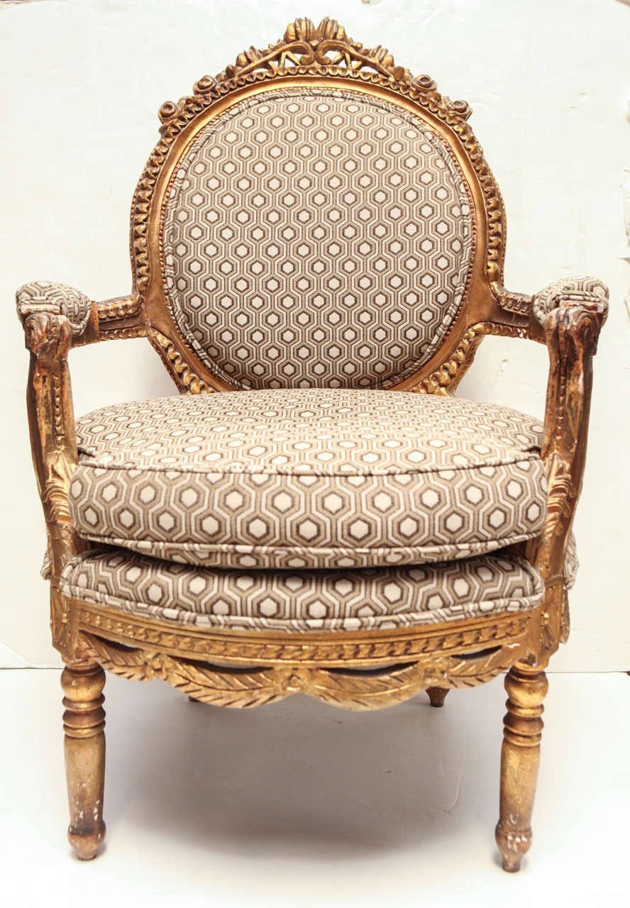 Pair of Louis XVI gold gilt round back armchairs with intricate detail throughout.  Upholstered in David Hicks classic honeycomb pattern.