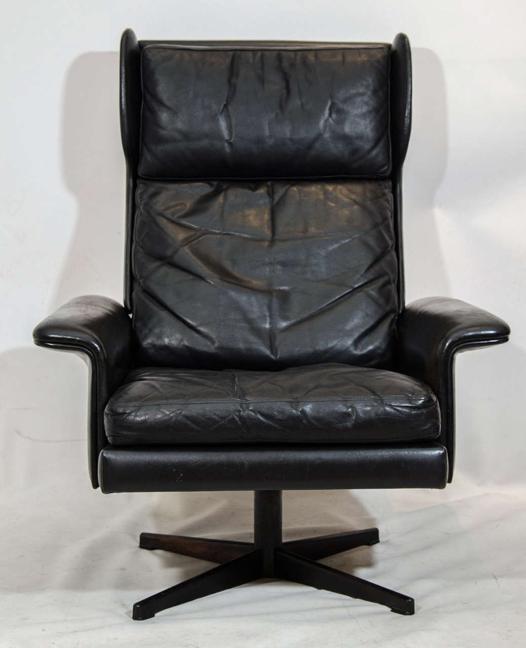 Handsome, high back black leather swivel lounge chair. Nicely designed as a modernist wingback. Please contact for location.