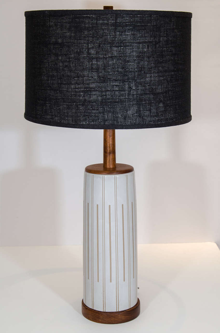 Grand, tall glazed pottery lamp with an incised pattern. Designed by Gordon Martz for Marshall Studios, the lamp has Martz' signature walnut stem which appears to extend up to the walnut finial. The lamp has a nice scale and presence. Please contact